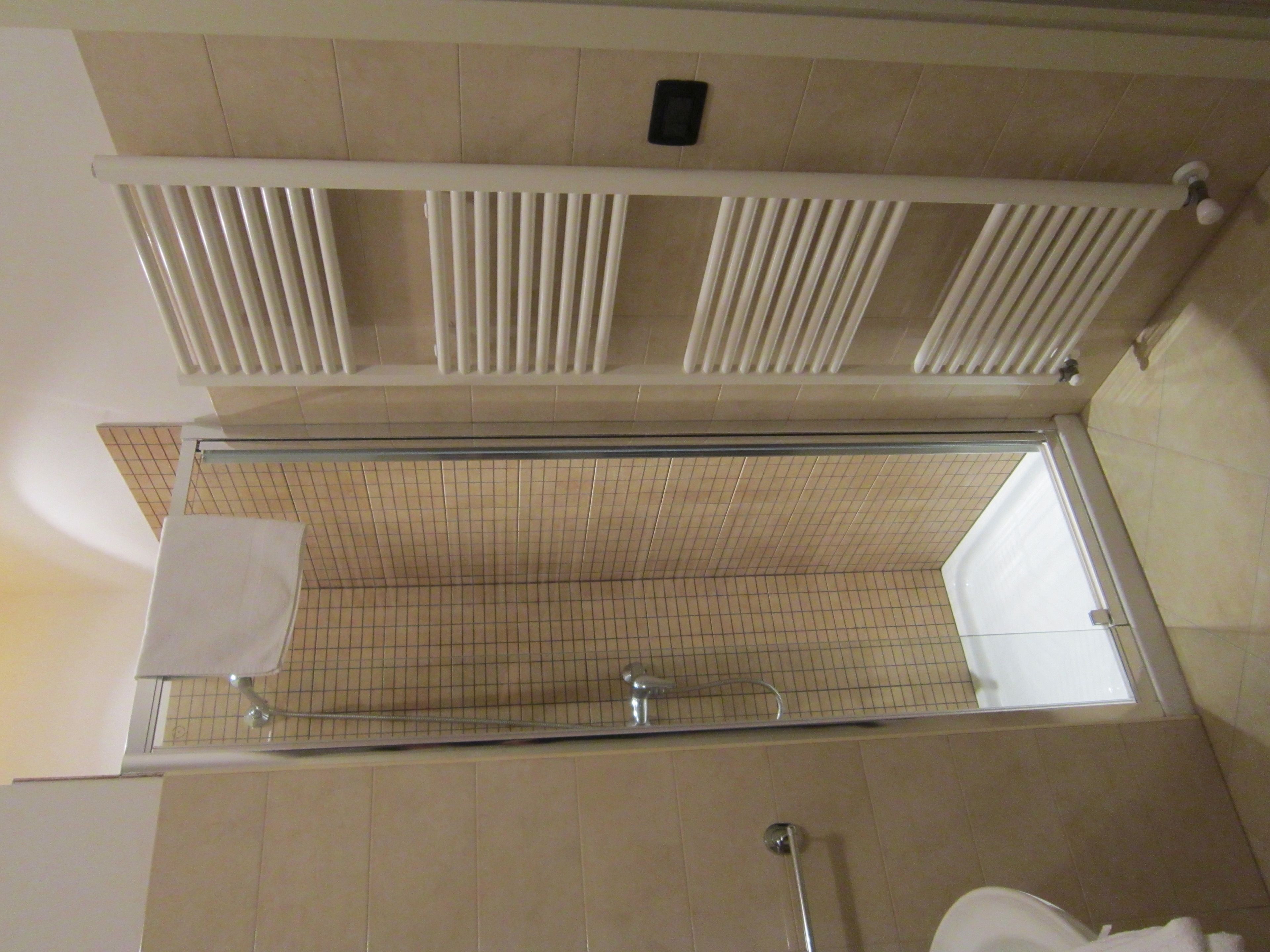 Ein Badezimmer mit Dusche, Toilette und Handtuchhalter.