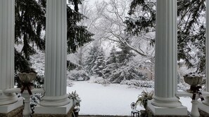 Un jardin enneigé avec vue à travers des colonnes.