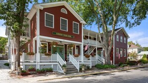 A two-story building with a porch, a sign reading 'Green Tree Inn,' and an American flag.