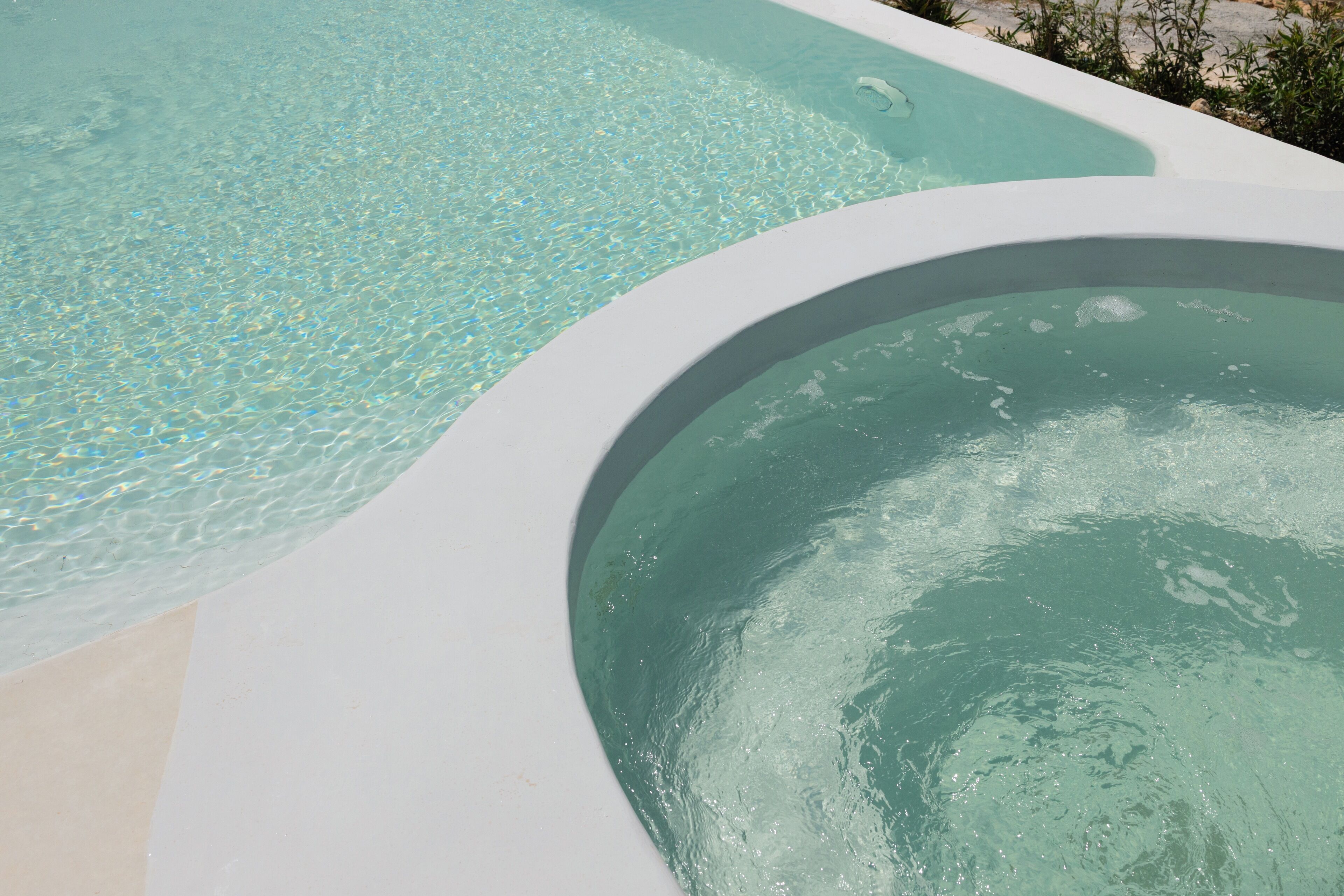 A swimming pool with clear water and a curved edge.