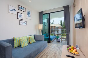 Una sala de estar moderna con un sofá, una mesa de comedor con fruta, un televisor y obras de arte en la pared.