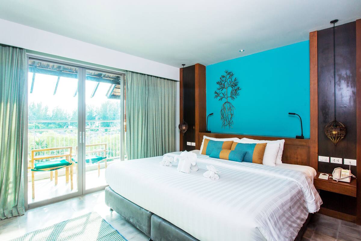 Une chambre d’hôtel dotée d’un grand lit, d’un balcon avec vue et d’un décor moderne.