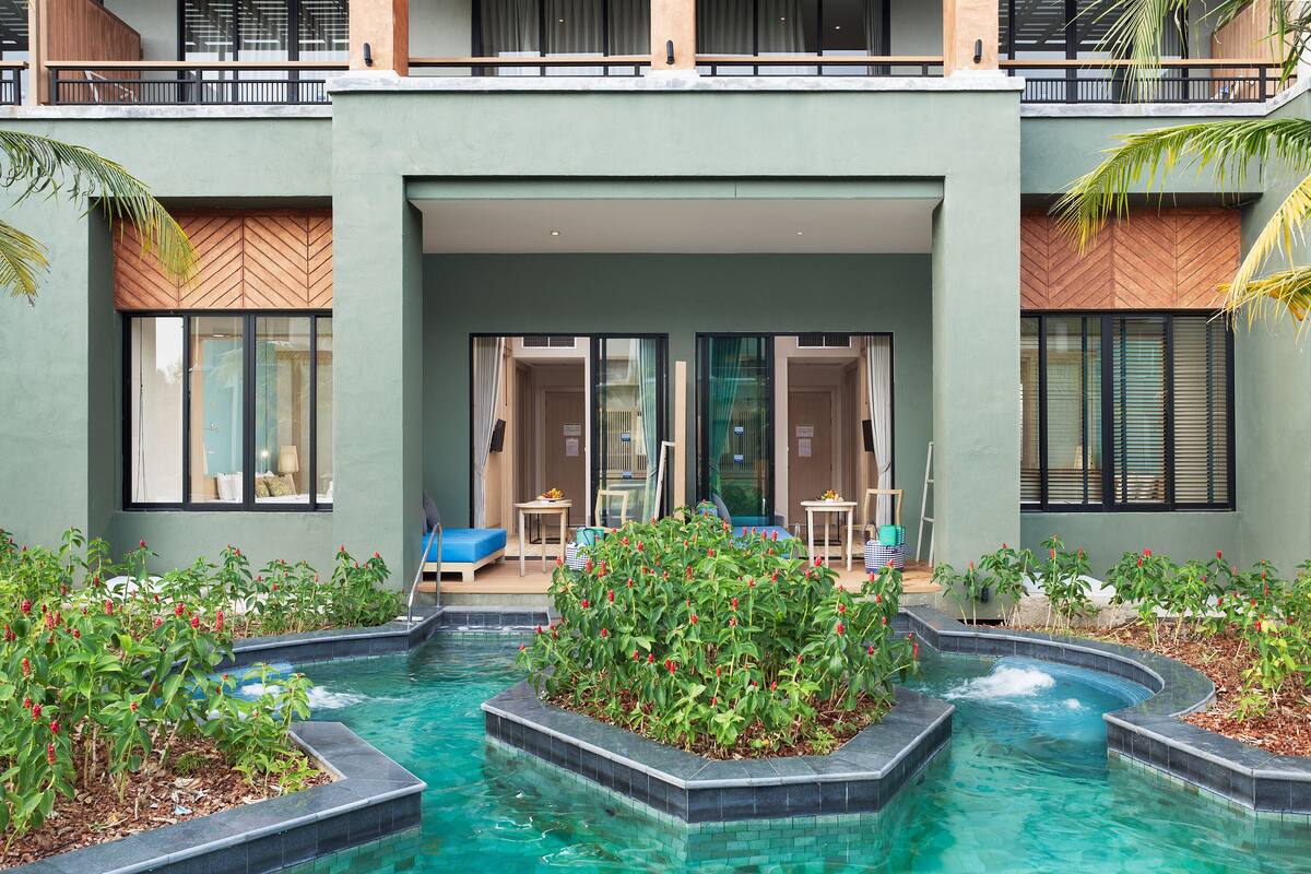 Un hôtel moderne doté d’une piscine, d’un espace extérieur aménagé et d’une entrée couverte.