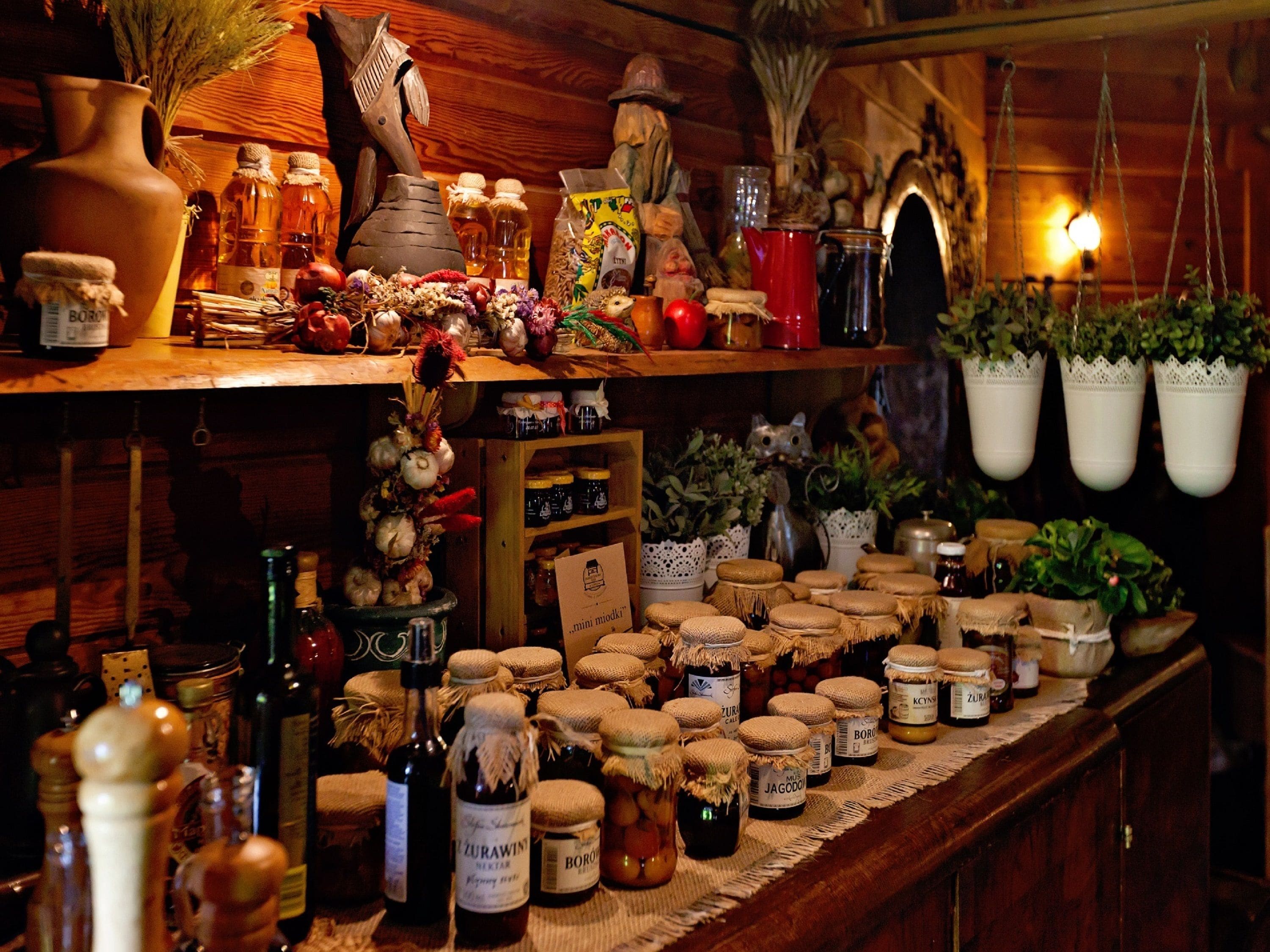 Une étagère en bois avec divers pots, bouteilles et plantes.