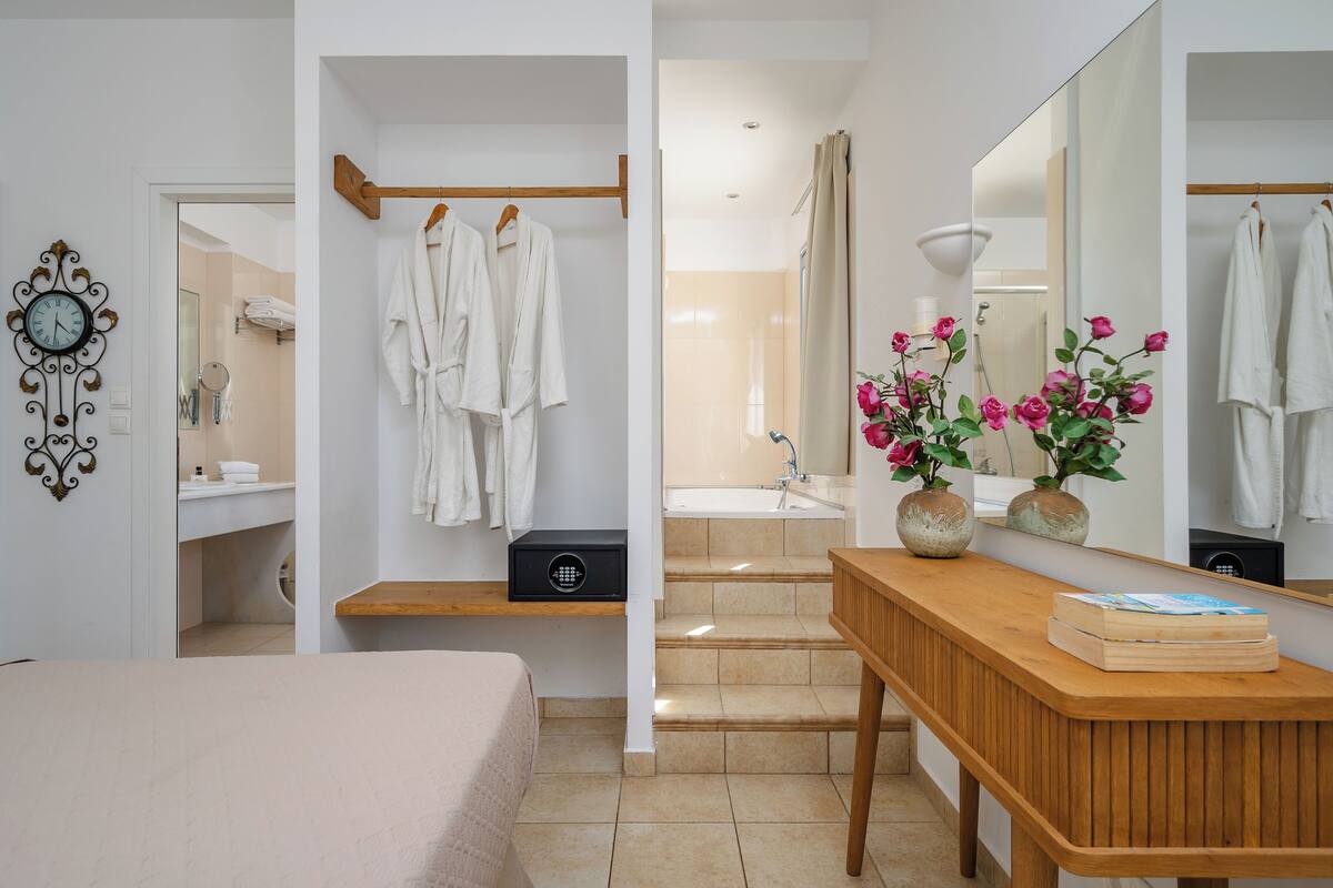 A modern bathroom with a wooden vanity, a mirror, and a shower area.