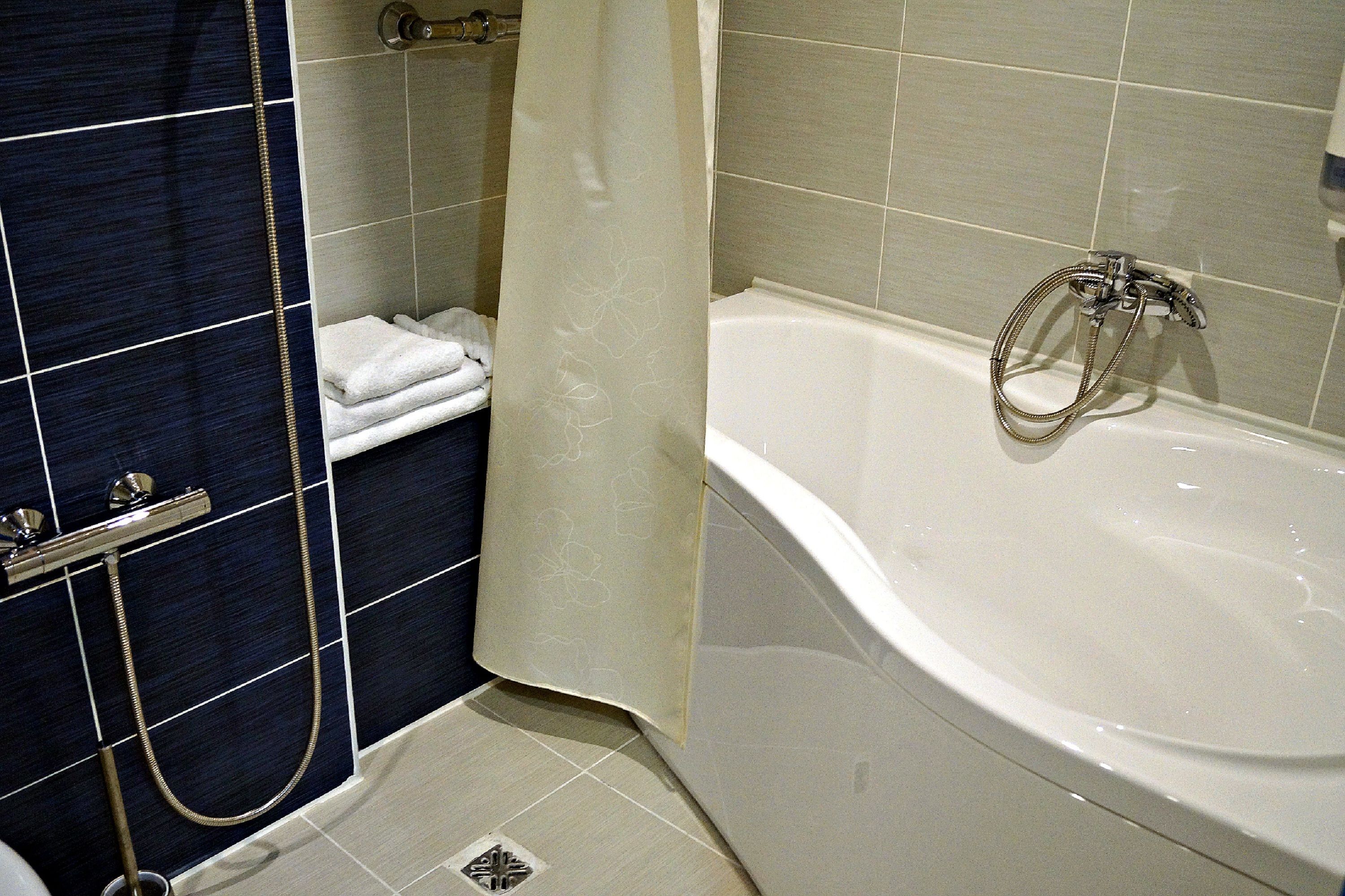 A bathroom with a bathtub, a shower, and a towel rack.