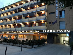 A hotel with multiple balconies and a restaurant named "Hotel Flora Parc" at the ground level. - Hotel Flora Parc (Castelldefels)