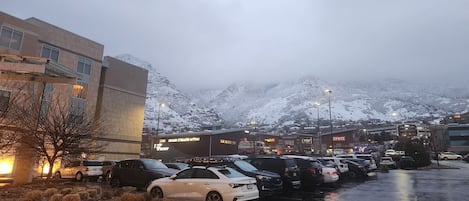 En parkeringsplats med bilar och en byggnad med en skylt där det står ”SPITZ”.