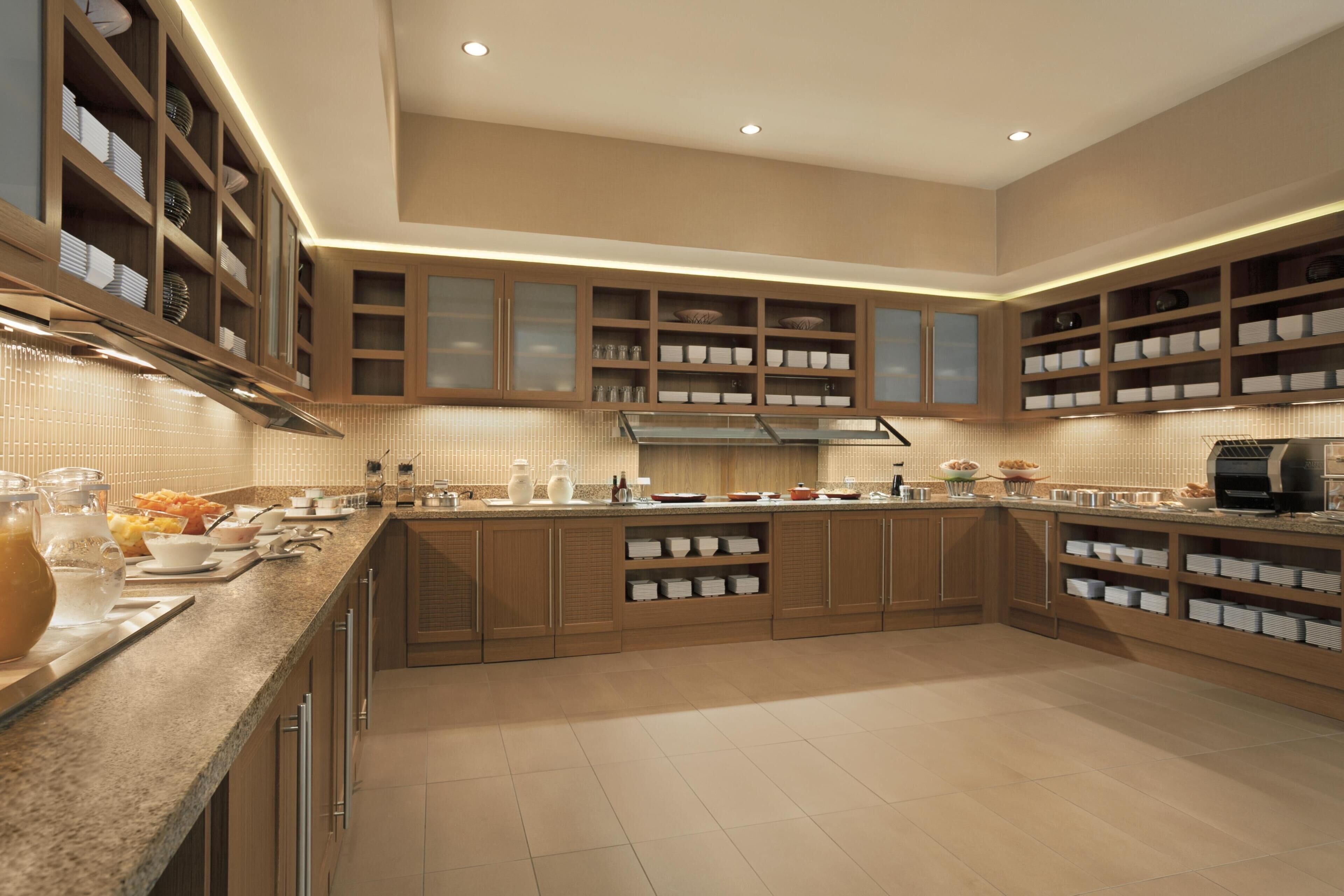 Una cocina amplia con armarios de madera, encimera de granito y estanterías empotradas.