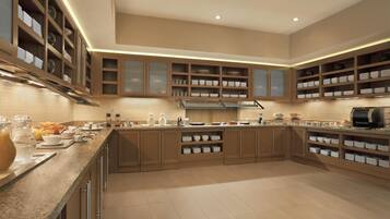 A spacious kitchen with wooden cabinets, a granite countertop, and built-in shelving.