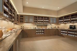 A spacious kitchen with wooden cabinets, a granite countertop, and built-in shelving.
