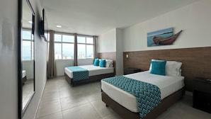A hotel room with two beds, a large window, a wooden headboard, and a painting of a boat on the wall. - Hotel Tower by On vacation (San Andrés)