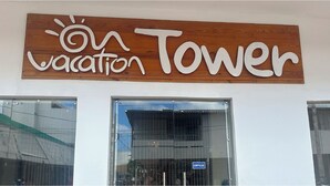 A sign for a vacation tower hotel with a wooden background and white lettering. - Hotel Tower by On vacation (San Andrés)