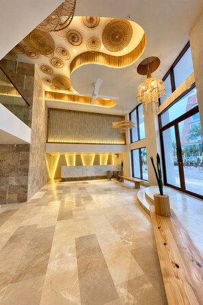 A spacious lobby with a marble floor, a reception desk, and a large window offering a view of the outside. -  Hotel Toné by On vacation (San Andrés)