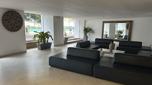 A modern living room with a sectional sofa, a coffee table, and potted plants.