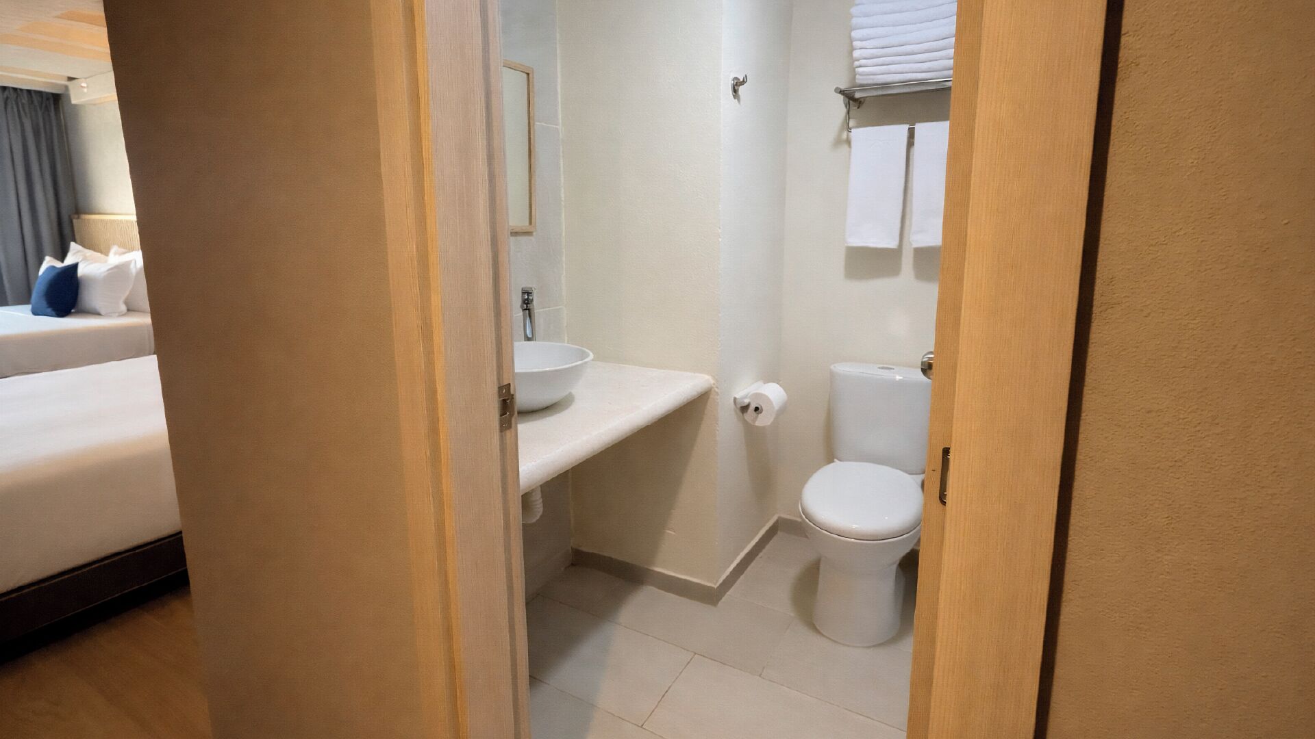 Une salle de bain d’hôtel équipée d’un lavabo, de toilettes et d’un porte-serviettes.