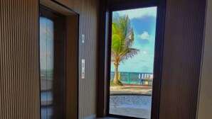 Un vestíbulo de hotel con suelo de baldosas, un panel de madera y una puerta que da al exterior.