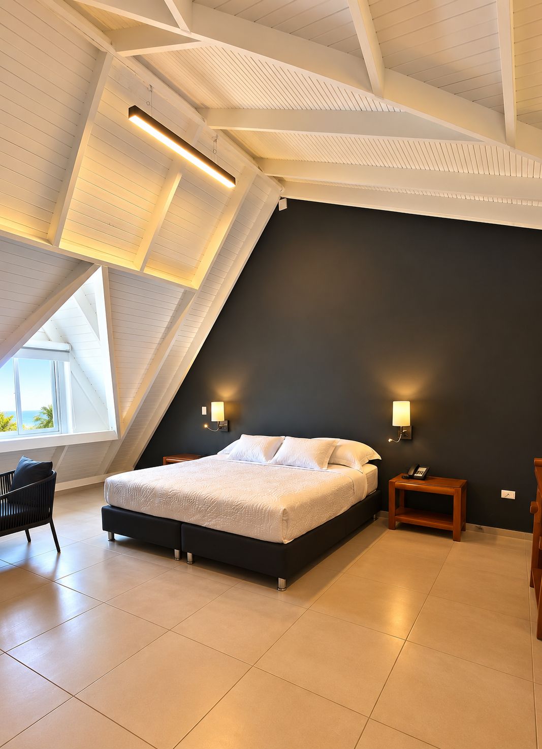 Une chambre avec un plafond en pente, un lit, des tables de chevet et une chaise.