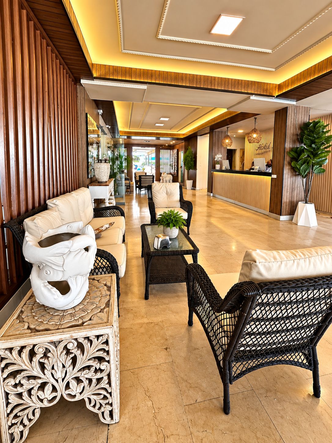 A hotel lobby with a reception desk, seating area, and decorative elements.