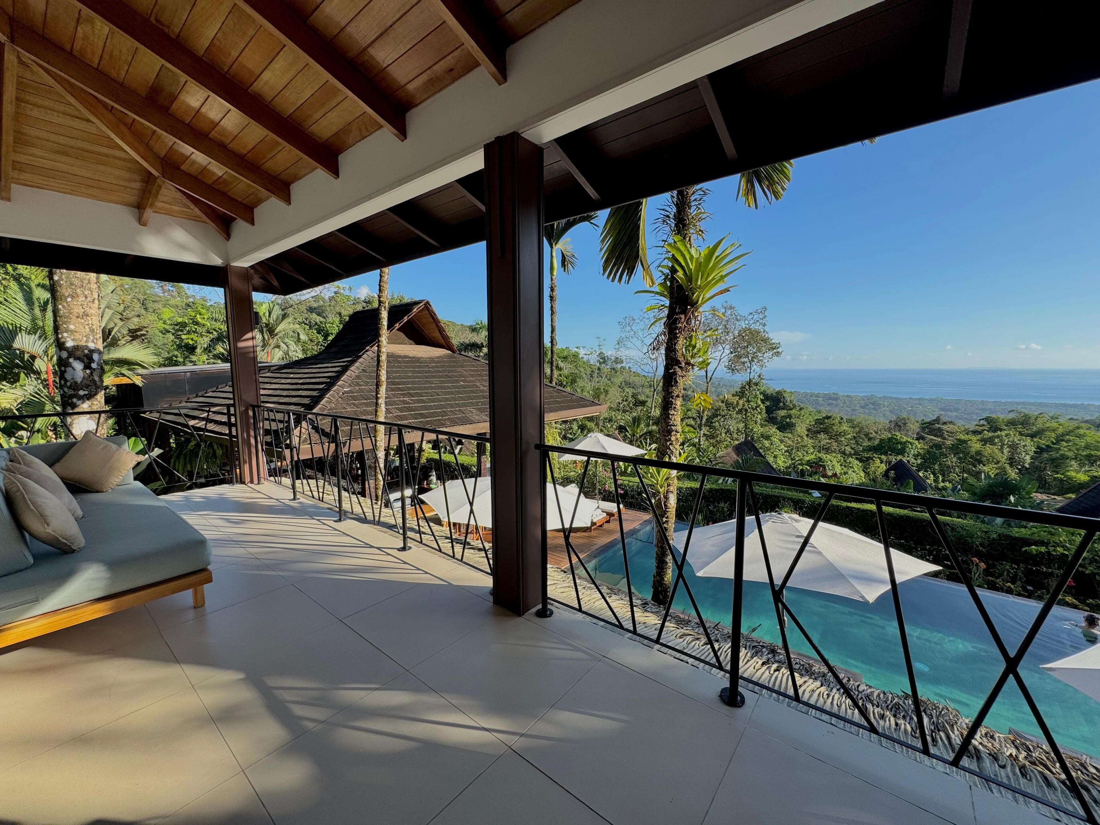 Un espace de détente extérieur moderne, avec un canapé et une vue sur la piscine.