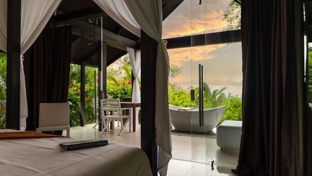 Une chambre avec un grand lit, un bureau et une baignoire.