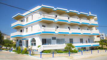 Un hotel de varios pisos con balcones, piscina y cafetería.
