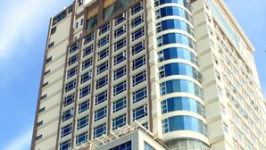 A multi-story hotel with a curved facade, numerous windows, and a prominent brand name at the top.