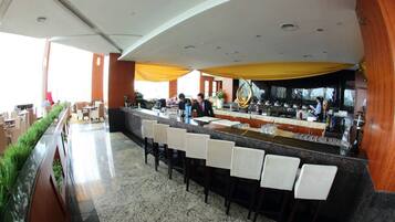 A modern bar area with a long counter and multiple bar stools.