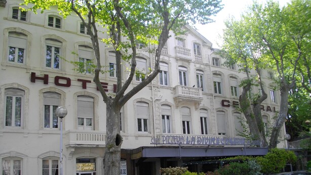 A hotel with a classic facade, multiple windows, and a sign for a restaurant. - Hotel Central (Carcassonne)