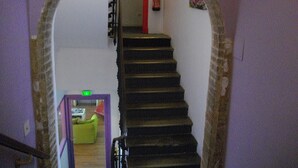 A staircase with a purple frame, a red fire extinguisher, and a green emergency exit sign. - Hotel Central (Carcassonne)