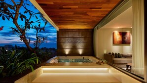 A modern bathroom with a wooden ceiling, a bathtub, and a seating area with a view of the sky. - Four Points by Sheraton Bali Seminyak (Keroboken Kelod)