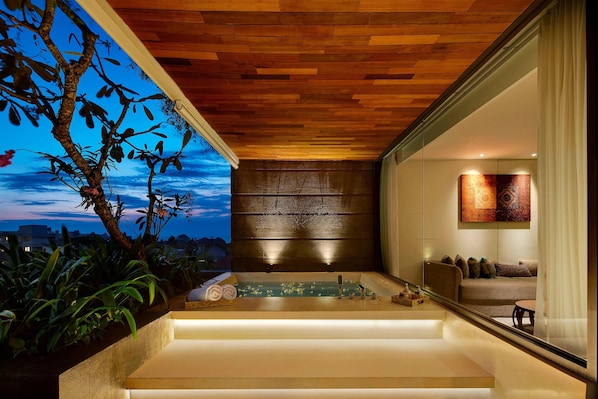 A modern bathroom with a wooden ceiling, a bathtub, and a seating area with a view of the sky. - Four Points by Sheraton Bali Seminyak (Keroboken Kelod)