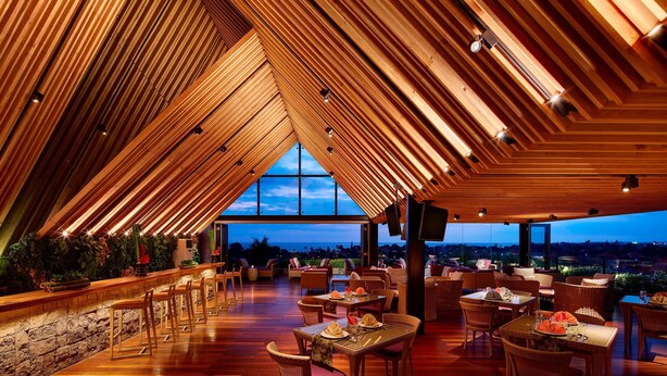 A restaurant with a high ceiling and wooden beams, featuring tables and chairs arranged for dining. - Four Points by Sheraton Bali Seminyak (Keroboken Kelod)