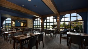 A spacious restaurant with high ceilings, large windows, and a modern interior design. - The Royal Hotel (Corfu)