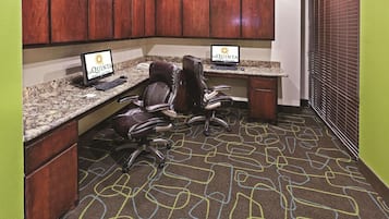 Un espace de bureau comprenant deux bureaux, des chaises et un tapis orné d’un motif géométrique.
