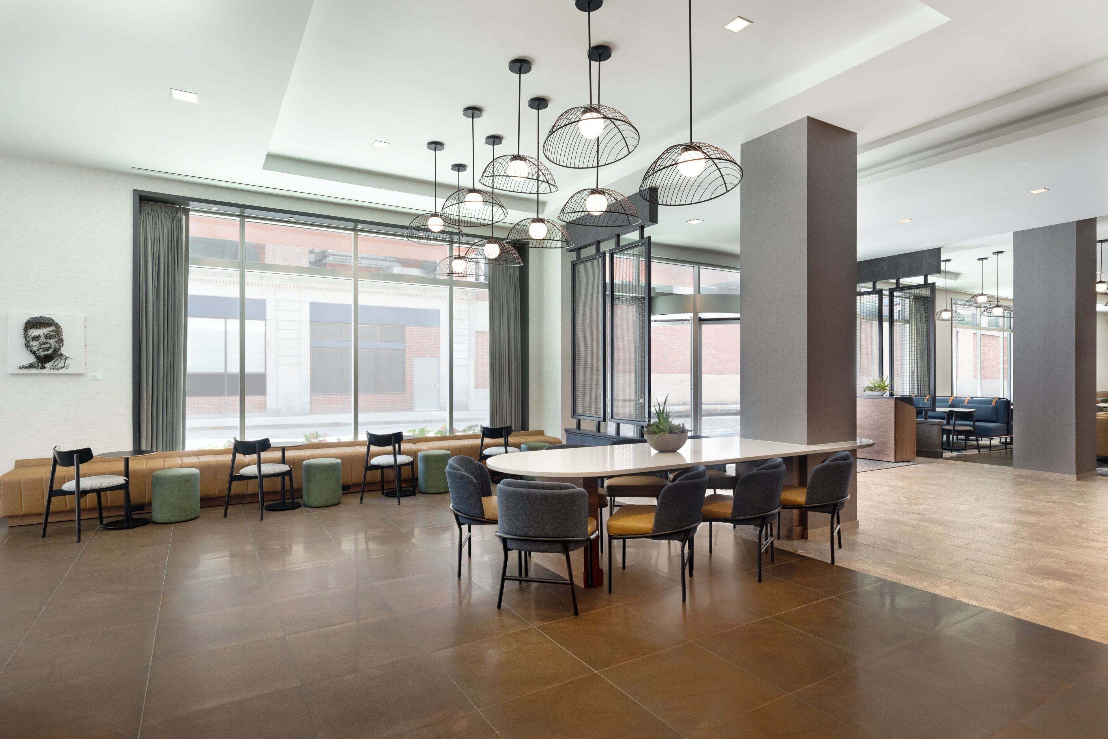 A spacious conference room with a large oval table, multiple chairs, and pendant lighting.