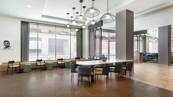 A spacious conference room with a large oval table, multiple chairs, and pendant lighting.