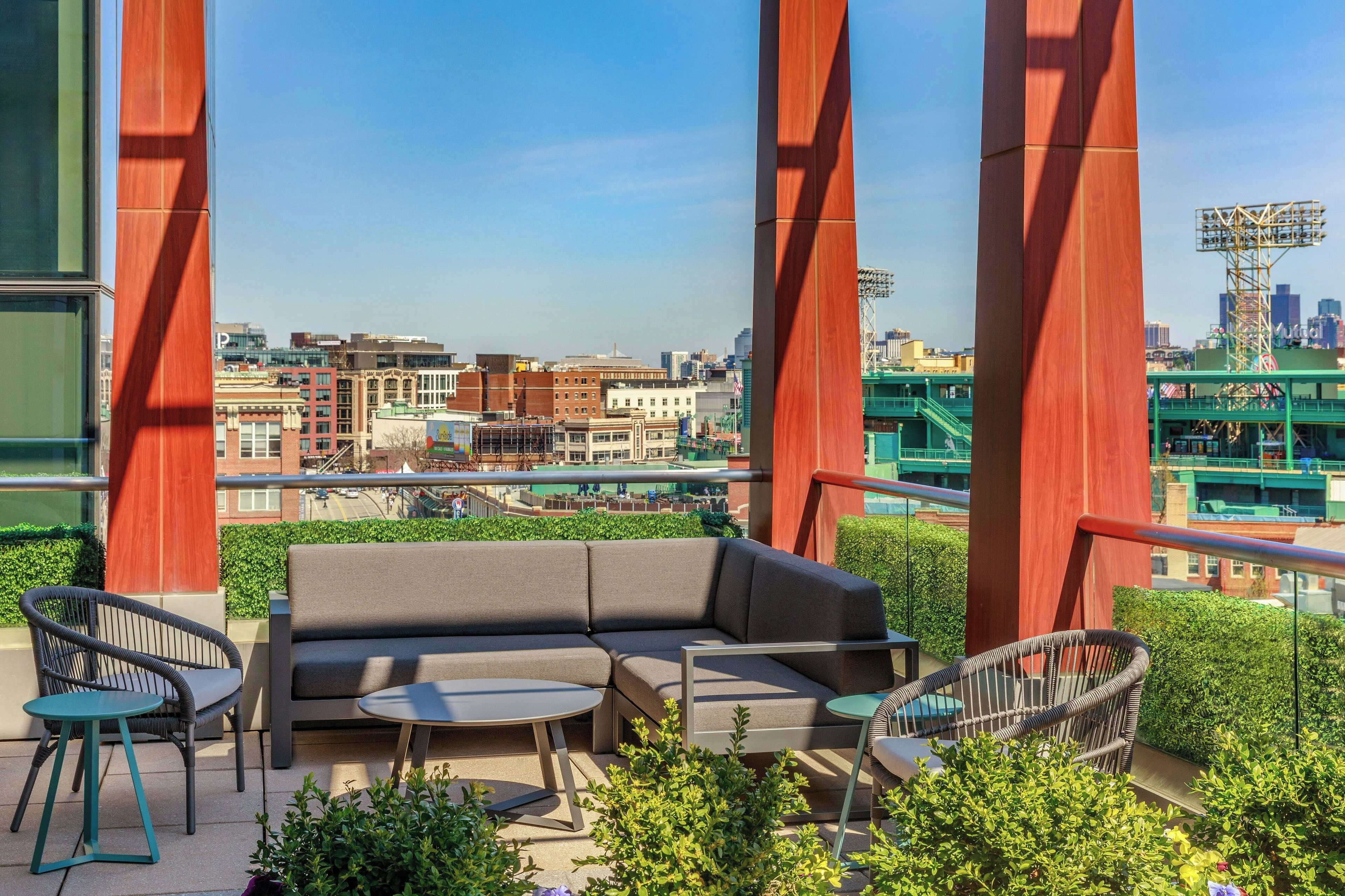 A balcony with a sofa, two chairs, and a small table.