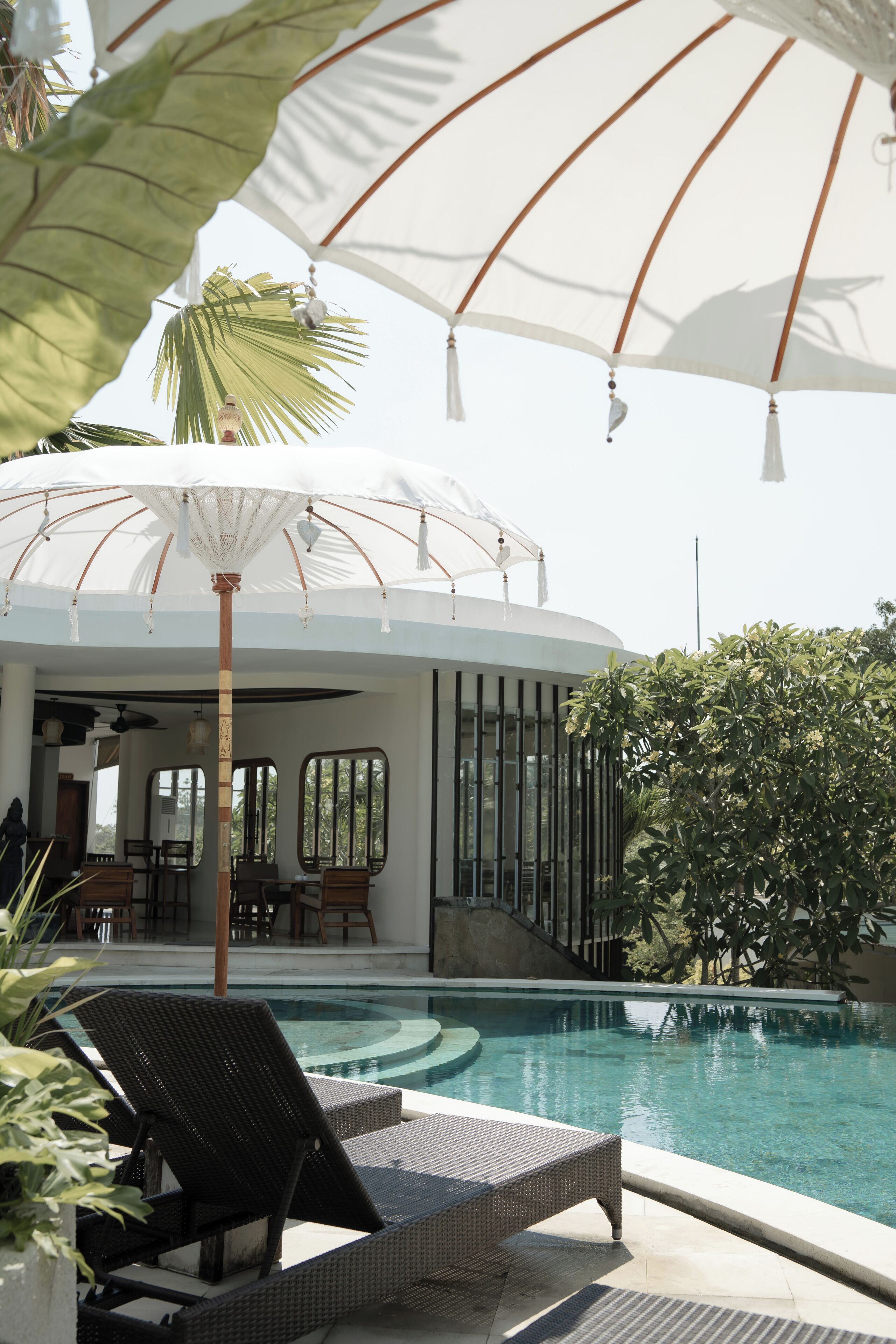 A pool area with lounge chairs and a covered seating area.