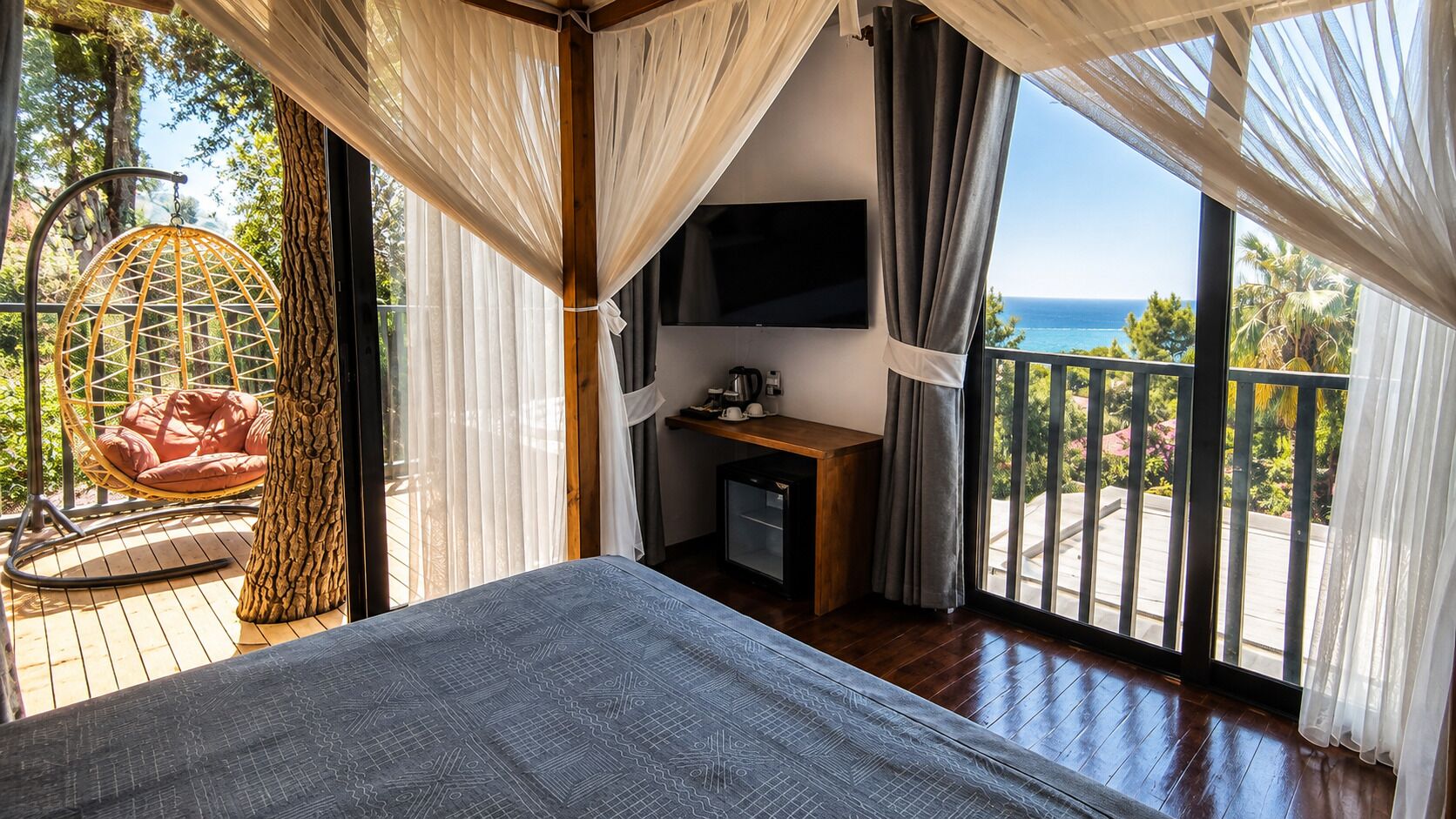 Une chambre avec un lit, un bureau, une télévision et une vue sur l’océan.