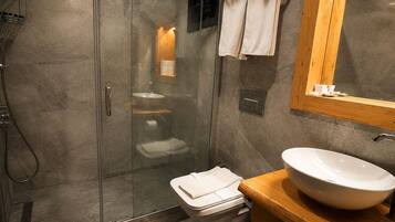 Une salle de bain moderne avec une douche à parois de verre, un lavabo blanc et un meuble-lavabo en bois.