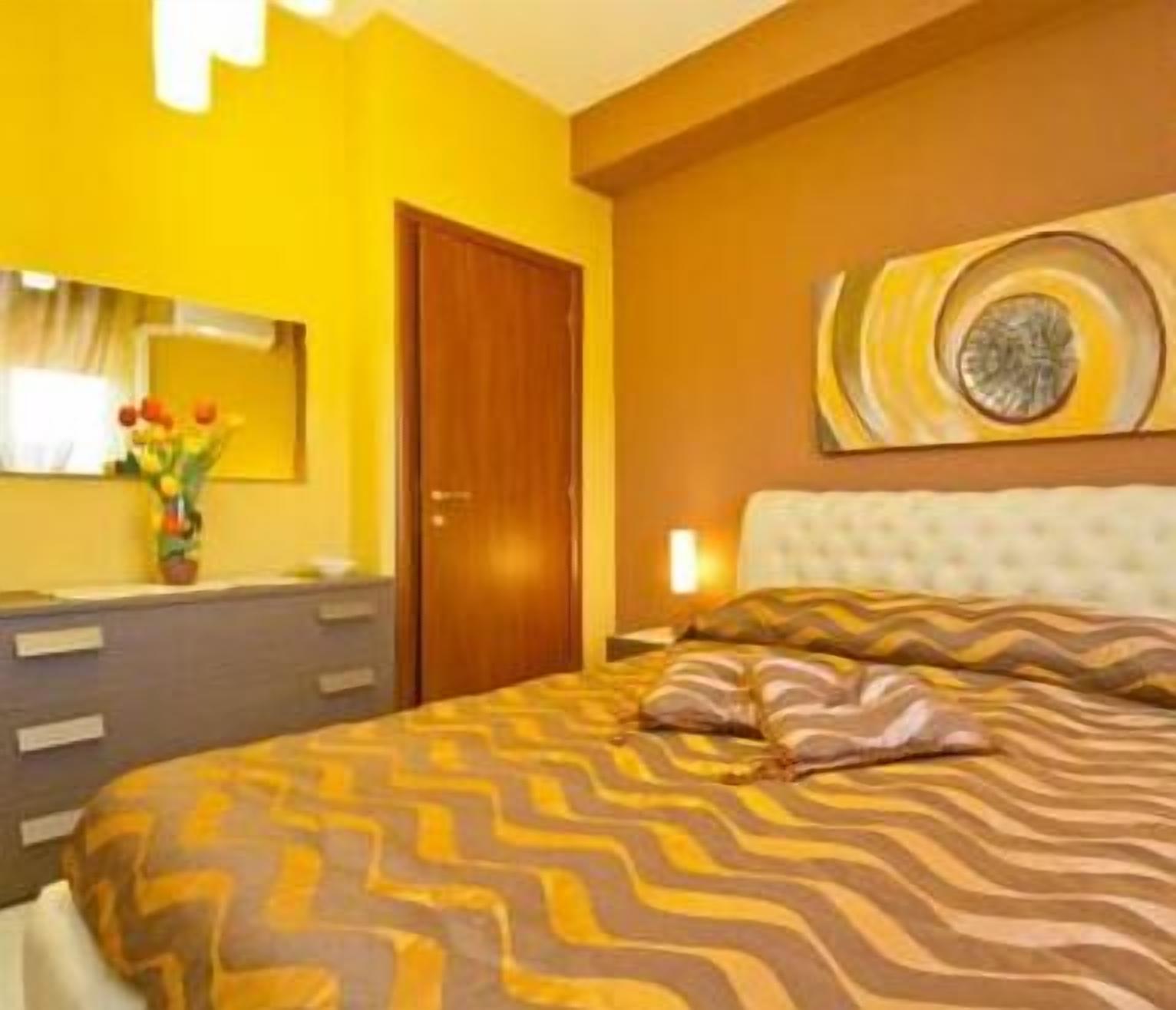 Une chambre à coucher comprenant un lit, une commode, un miroir et un élément décoratif mural.