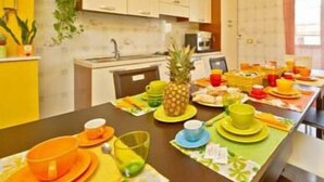 A dining area with a table set for breakfast, including plates, cups, and a pineapple. - Il Girasole Bed and Breakfast (Palermo)