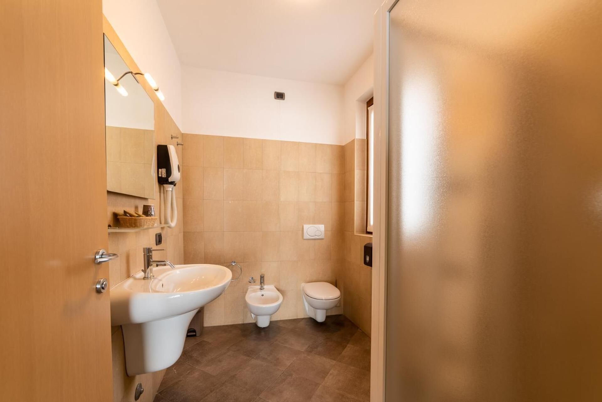 Een moderne badkamer met een wastafel, toilet en bidet.