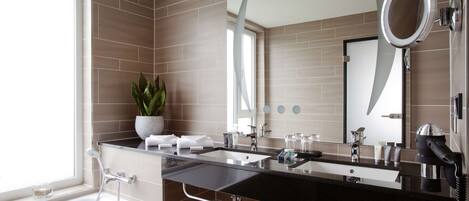 A modern bathroom with a dual sink vanity, a large mirror, and a hairdryer.