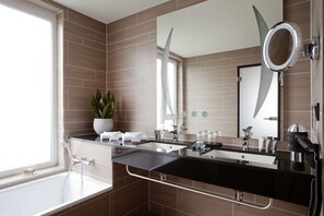 A modern bathroom with a dual sink vanity, a large mirror, and a hairdryer.