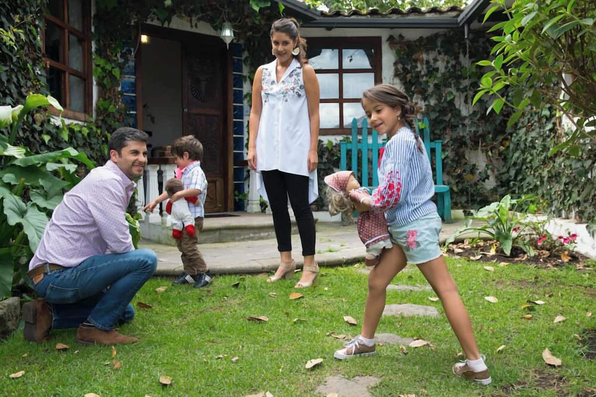 A family in a garden with a house in the background.