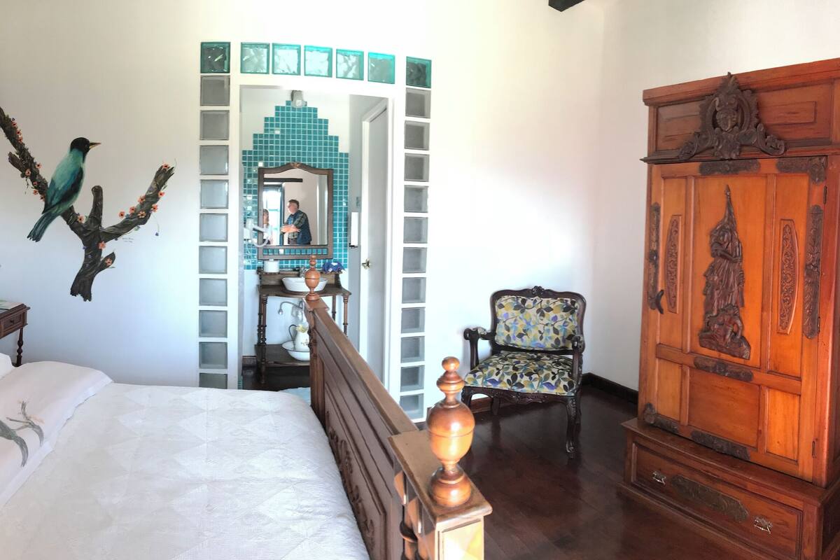 A bedroom with a wooden bed, a nightstand, a chair, and a wardrobe.