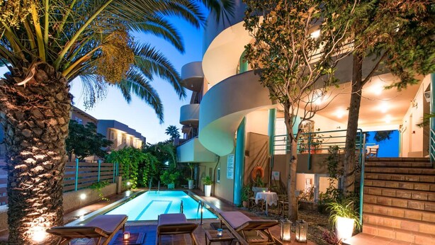 Zona junto a la piscina con sillas de descanso, una piscina y una escalera que sube a un nivel superior.