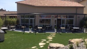 A patio area with outdoor seating and a glass enclosure.